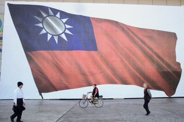 2024年1月13日，新北市民众行经一面台湾国旗。（图片来源：AFP/SAM YEH/Getty Images）