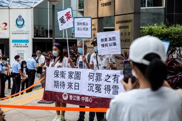 2021年7月22日，被告的支持者在香港湾仔地方法院外举着标语牌，七名男子因2019 年在香港元朗地区袭击民主抗议者而因不同的骚乱和伤人罪名而面临判刑。（图片来源：ISAAC LAWRENCE/AFP via Getty Images）