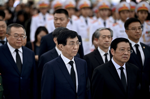 2024 年 王沪宁(中)在河内举行为期两天的全国哀悼活动的第一天,在国家殡仪馆向已故越南共产党总书记阮富仲表示敬意。