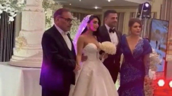 影片中可见，伊朗前国家安全高层沙姆哈尼（Ali Shamkhani）的女儿头发披散、穿着露肩婚纱走进会场。