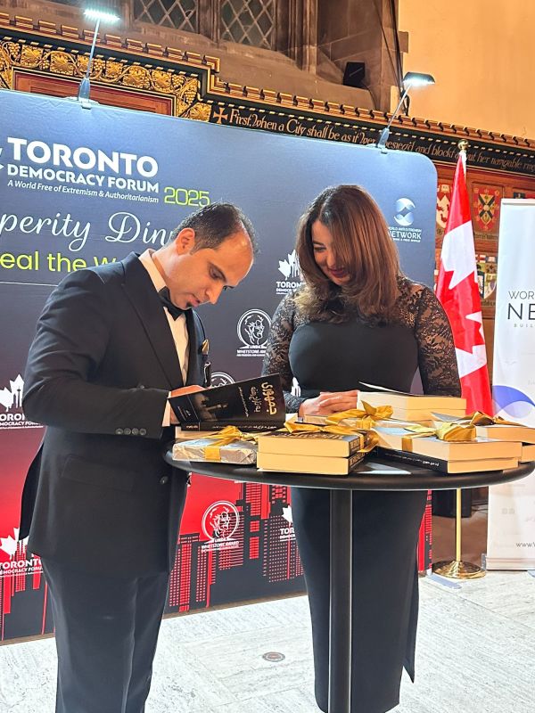 2025年11月17日，世界反极端主义网络（WAEN）首席执行官哈立德·拉米齐（Khalid Ramizy）在多伦多民主论坛首日的繁荣晚宴上为新书《被窃取的共和国》（The Stolen Republic）举行签名售书活动（WAEN推特账号）