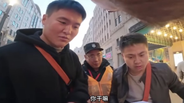 「白紙運動」三週年,一名男子在上海外灘舉旗被便衣警察搶奪。