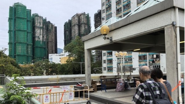 宏福苑发生大火惨剧一周后,唯一未受波及的大楼住户3日获得批准回家取回物品;图左有围网大楼就是未受大火波及的宏志阁。(图片来源:中央社)