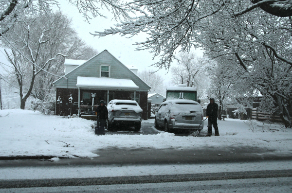 2024年2月13日,新泽西州北瓦尔市,居民们在飘雪中清理自家车道。