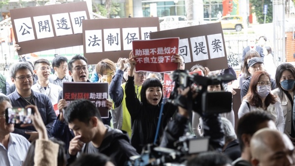 國民黨立委陳玉珍提出助理費除罪化修法,引發討 論。立法院國會助理工會12日上午號召國會助理,在 立法院大門口舉牌發表訴求、捍衛工作權益。