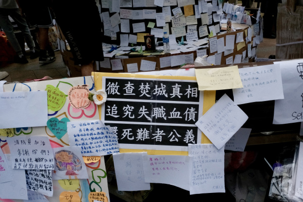 2025年12月2日，人們在宏福苑大樓外，設立臨時紀念場所，擺放著悼念者的留言。（圖片來源：Tommy WANG / AFP via Getty Images)