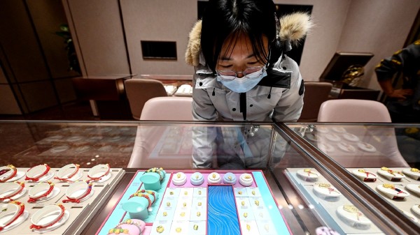 2024年2月5日，顯示一位顧客正在北京周大福店瀏覽陳列的黃金首飾。（圖片來源：JADE GAO/AFP via Getty Images)