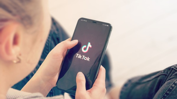一位女生正在用手機玩TikTok