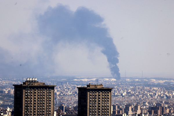 2025年6月17日，以色列袭击伊朗首都德黑兰，远处的炼油厂浓烟滚滚。