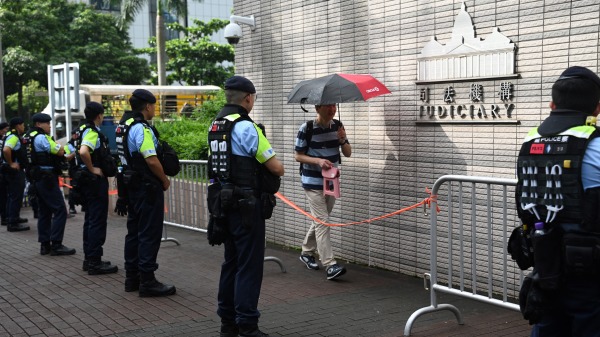 港警注視著進入香港西九龍裁判法院的人們。（圖片來源：PETER PARKS-AFP via Getty Images)