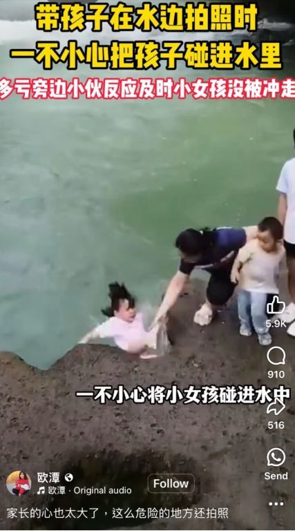 母親帶孩子站在流水旁，不小心把孩子碰到水裡