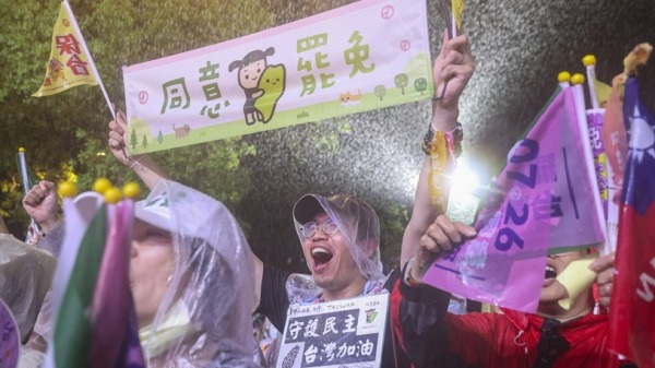 反共護台志工聯盟25日選前之夜在立院旁舉行晚會，民眾在風雨中高喊口號支持罷免。（以上圖片來源皆為中央社）