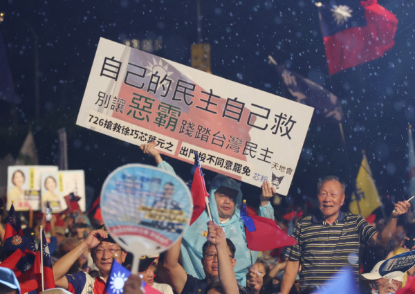 藍營反罷免選前之夜，許多民眾冒雨出席，並高舉看板表達立場。