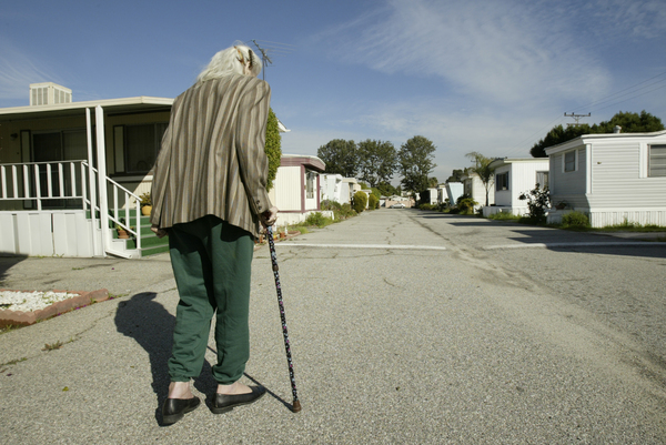 一位老婦走向自己的移動房屋住所