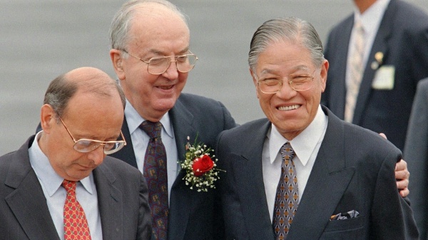 1995年6月8日,在錫拉丘茲舉行的歡迎儀式上,美國參議員傑西·赫爾姆斯(中)擁抱台灣總統李登輝(右),參議員阿方斯·達馬托宣讀致詞。李登輝獲準以私人身分造訪其母校康乃爾大學