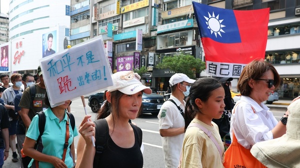 台灣公民陣線、台灣經濟民主連合等民團23日在台北舉行「真和平,要國防」523遊行,有民眾手持「和平不是跪出來的」標語,高呼口號參加遊行。