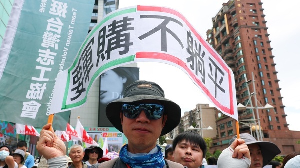 台灣公民陣線、台灣經濟民主連合等民團23日在台北舉行「真和平,要國防」523遊行,與會民眾高舉「要軍購不躺平」標語表訴求。