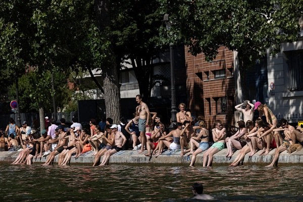 2026年7月12日,在法國巴黎,民眾坐在聖馬丁運河(Canal Saint-Martin)畔納涼休憩。當時法國正遭遇熱浪侵襲。