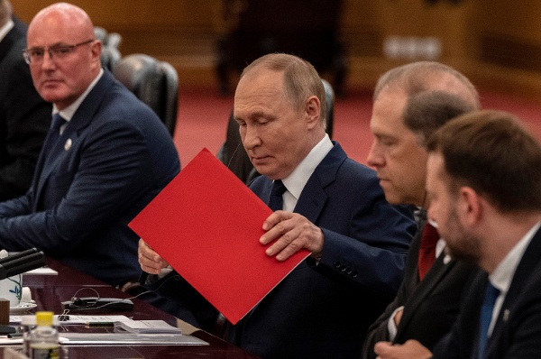 2025年9月2日,中國北京,俄羅斯總統普京(Vladimir Putin)在人民大會堂與中國國家主席習近平(未入鏡)舉行雙邊會談開始前整理文件。