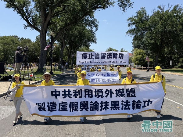 遊行隊伍的第二方陣「停止迫害法輪功」,法輪功學員拉著「中共利用境外媒體製造虛假輿論抹黑法輪功」的橫幅