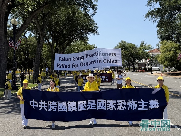 遊行隊伍的第二方陣「停止迫害法輪功」,法輪功學員拉著「中共跨國鎮壓是國家恐怖主義」的橫幅