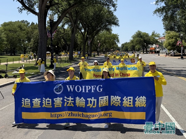 遊行隊伍的第三方陣,法輪功學員拉著「追查迫害法輪功國際組織」的橫幅