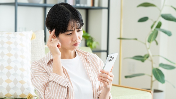 女子看著手機思考