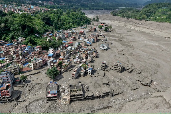 2026年8月26日，尼泊爾努瓦科特地區特里蘇裡巴扎爾（Trishuli Bazar），突發洪水過後，河岸邊的房屋部分浸泡在泥水中。