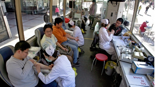 2007年11月17日，一些中国男性在一辆北京的流动献血车内献血。（图片来源：TEH ENG KOON/AFP via Getty Images）