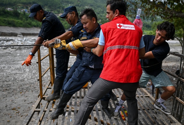 2026年9月4日:山洪暴發後,尼泊爾警察人員在特里舒利河(Trishuli River)兩岸拉動臨時搭建的手動滑索。