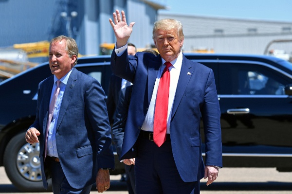 美国总统唐纳德·川普(Donald Trump)于2020年6月11日抵达得州达拉斯时挥手致意,身旁是得州总检察长肯·帕克斯顿(Ken Paxton,左)。