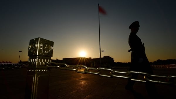 圖為一名軍人在人民大會堂前的天安門廣場巡邏。（圖片來源：MARK RALSTON/AFP via Getty Images）