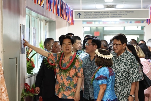 總統賴清德（前左）結束夏威夷過境行程，當地時間3日抵達太平洋友邦馬紹爾群島，下午參訪馬久羅醫院，賴總統指著牆上照片與旁人互動。