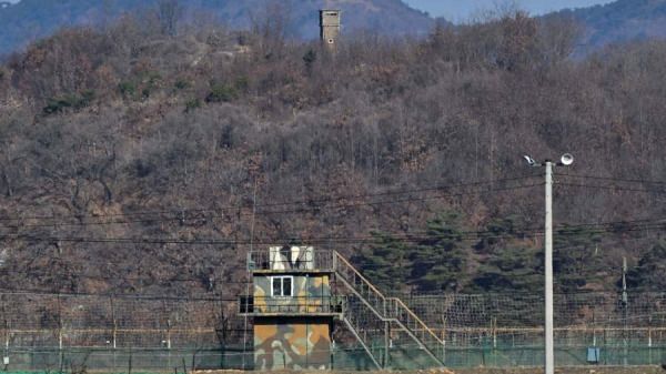 2023年3月13日，從邊境城市坡州可以看到韓國軍事圍欄（下）上方的朝鮮哨所（上）。