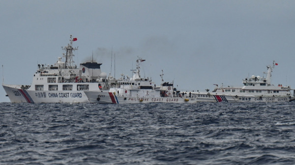 2024年8月26日，中国海警船（背景左和右）经过菲律宾海警船 BRP Cape Engaño（中），这是在南海争议水域萨比纳浅滩（Sabina Shoal）执行补给任务期间从 BRP 卡布拉号拍摄的照片。