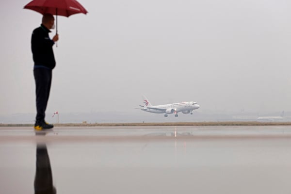 2022年12月9日，一名男子在上海觀看中國商用飛機有限責任公司C919飛機降落在虹橋國際機場。