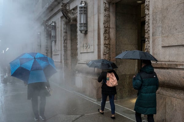 2024年4月3日，“东北风暴”肆虐时，撑伞行人穿行雨中。