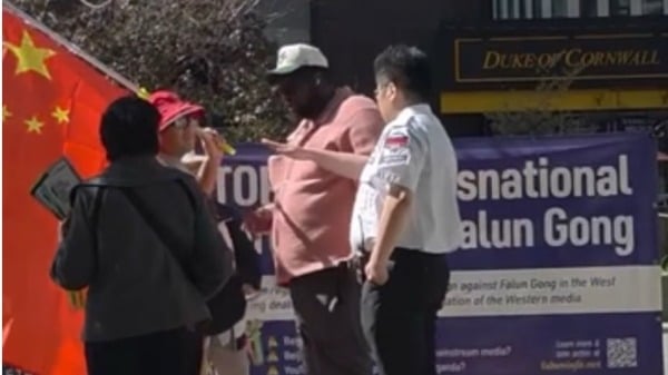图为393大楼保安（右）和一名路人上前阻止该男子谩骂法轮功人士（潘学峰提供