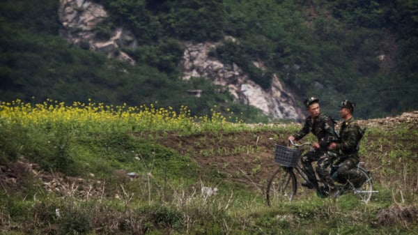 2017 年 5 月 23 日，朝鮮士兵騎著自行車行駛在朝鮮邊境城市新義州以北的鴨綠江上，與中國遼寧省丹東市隔江相望。