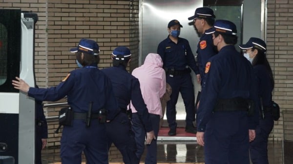 涉虐死男童「剴剴」的保母劉彩萱（粉色外套）在法警戒護下進入台北地方法院。（圖片來源：中央社）