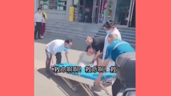 河南禹州一名女子被戴上手銬，強行抬上擔架帶走。