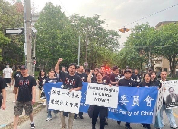 中國民主黨加拿大委員會黨員馬小傑參加多倫多紀念六四36週年遊行（前排持展板）
