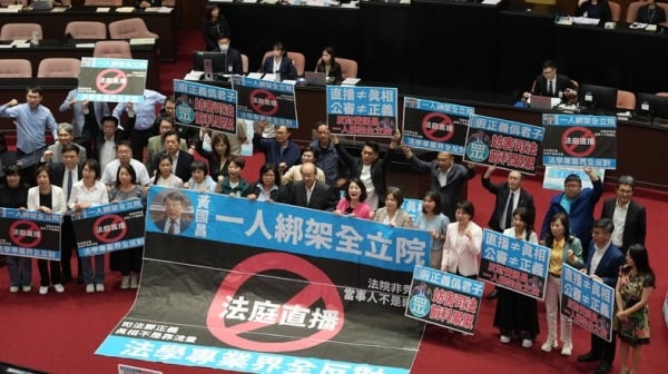 立院处理法院组织法部分条文，民进党团则摆出标语，以示反对。（图片来源：中央社）