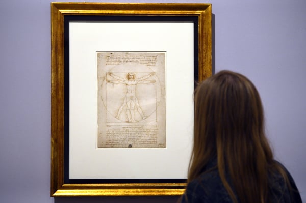 一名女子正在觀看達．芬奇（Leonardo da Vinci）創作的《維特魯威人》（Vitruvian Man）素描，拍攝於2013年8月2日，地點為威尼斯。