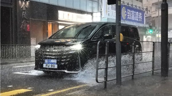 香港4日晚起雷電交加兼下暴雨，圖為轎車在積水的馬路翻起水花。