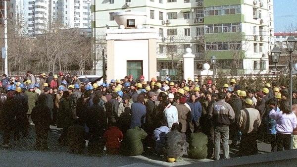 2003年1月17日，數百名工人在北京一處高檔住宅區入口處進行封堵，要求支付被拖欠了一年的工資。（圖片來源：AFP via Getty Images）