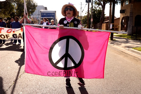 2026年1月17日，在长滩马丁·路德·金大道举行的第38届马丁·路德·金纪念游行暨庆祝活动中，一名“粉红代码”（Code Pink）组织的成员正在游行。这场游行是一项历史悠久的传统，旨在庆祝长滩市中心多元化的社区。该节日旨在纪念和传承金博士的理想。（图片来源：Genaro Molina/Los Angeles Times via Getty Images)）