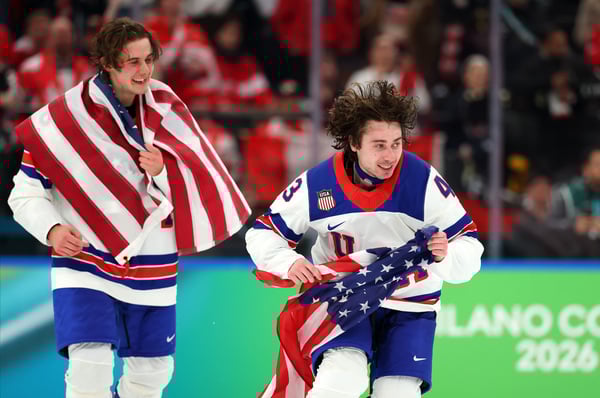 2026年2月22日：在2026年米兰-科尔蒂纳冬奥会第16天的男子冰球金牌争夺战中，美国队在加时赛中以2比1战胜加拿大队，夺得金牌。图为打入绝杀一球的美国队队员杰克·休斯（86号，右）和他的兄弟奎因·休斯（43号）庆祝胜利。