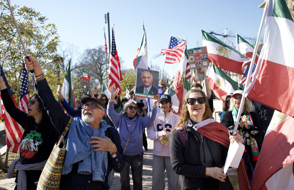 2026年2月28日，在华盛顿特区的一场集会上，人们挥舞伊朗国旗，并展示伊朗政治活动家雷扎·巴列维（Reza Pahlavi）的照片，以表达对美国和以色列可能对伊朗伊斯兰共和国政府采取军事行动的支持。