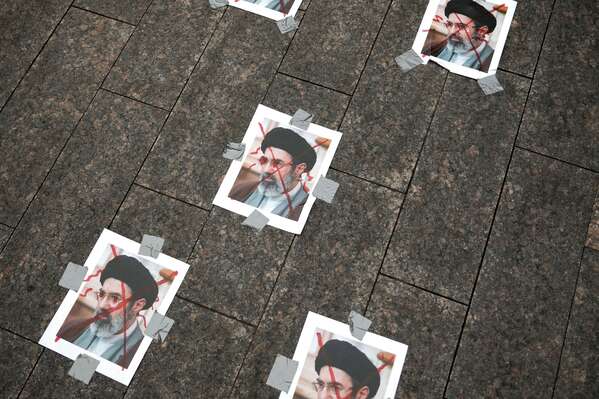 被劃掉的伊朗新任最高領袖穆傑塔巴．哈梅內伊（Mojtaba Khamenei）的肖像被貼在地面上。